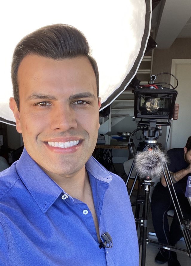 Daniel nos bastidores de uma gravação, com câmera e luz ao fundo