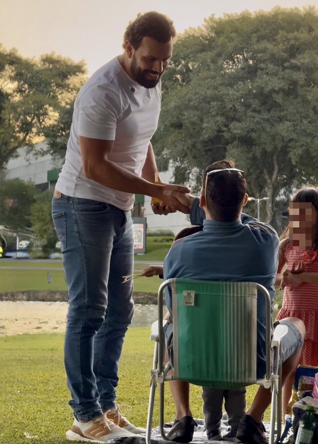 Daniel cumprimentando uma família em um parque